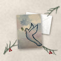 Peace Dove watercolor holiday card on linen with white envelope, pine sprigs and red berries