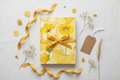 Yellow floral watercolor journal gift flat lay with ribbon and dried flowers on linen